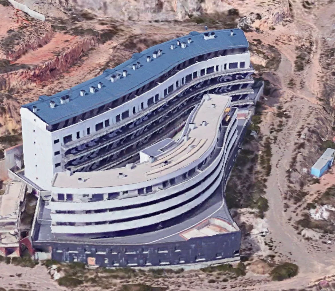 Vista aérea de un edificio de viviendas en curva sobre la ladera